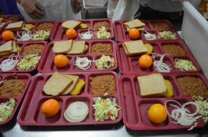 La comida que se sirve en Adelanto. Dos pedazos de pan, cebolla cruda, frijoles, ensalada, y una naranja. Foto: Alonso Yáñez/La Opinión.