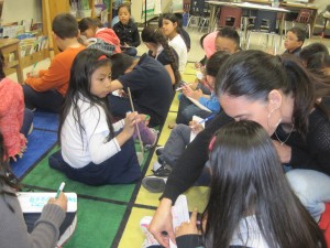 La maestra Laura González ayuda una alumna. Foto: Zaidee Stavely