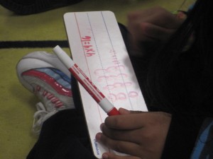 Los niños de la clase de la Maestra González en la Academia Bridges usan dibujos, números, y palabras para resolver problemas. Foto: Zaidee Stavely