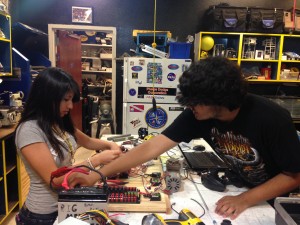 Dianna Valenzuela y Sergio Corral, 17 y Diana Valenzuela, 16 trabajan juntos en el panel de control de un robot acuático.