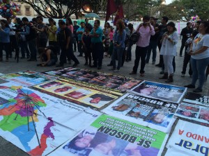 Miembros de la caravana despliegan carteles con las fotos de sus seres queridos desaparecidos. Foto: Raúl Silva.