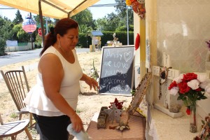 Concepción Domínguez limpia un altar para Andy López en el lugar donde murió. Vecina de López, dice que preferiría que Gelhaus no patrullara las calles. “Es demasiado peligroso”. Foto: Farida Jhabvala Romero/KQED