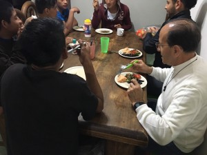 El padre Alejandro Solalinde cenando con los jóvenes en el albergue.