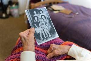 Florence Marquez holds a old photograph of her and her sisters. (Heidi de Marco/KHN)