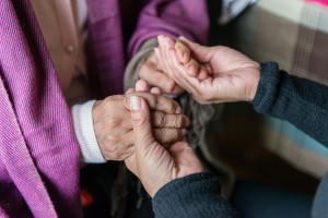 Tania Yanes holds her mother’s hands on Sunday, November 27, 2016. “I try to make her feel comfortable, feel safe.” said Yanes. (Heidi de Marco/KHN)