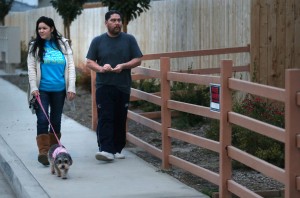 Juan y Julie Solís salen de paseo con su perra Gigi por el vecindario. Foto: Casey Christie / The Bakersfield Californian