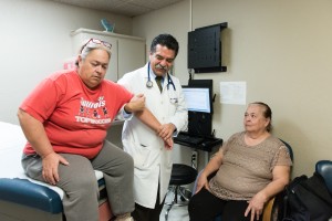 Luis Bautista, an internist at Bautista Medical Center in Fresno, Calif., examines Kathy Macias, 53, while her mother, Connie Hernandez, 72, waits to be seen on February 8, 2017. Bautista says the majority of his patients are afraid of losing the health insurance they received under the Affordable Care Act. (Heidi de Marco/KHN)