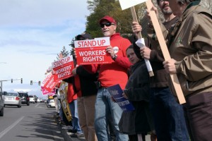 Manifestantes desplazados de sus empleos se alinean en las calles cerca de la jefatura de T-Mobile durante una manifestación que desacreditaba la decisión de la compañía de cerrar siete centros de llamadas. Foto: Bellevue Reporter.