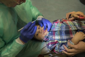 Ray Stewart, a pediatric dental professor at the University of California-San Francisco, examines Matthew Mai, 2, of Vallejo, Calif. Stewart has been treating infants for more than 15 years. (Robert Durell for Kaiser Health News)