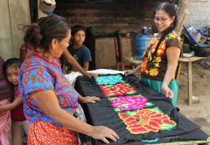 Bettina aprecia la ropa típica de su cultura con que se viste. En lo imagen platica con una vendedora de telas juchiteca. Foto: www.desinformemonos.com. 