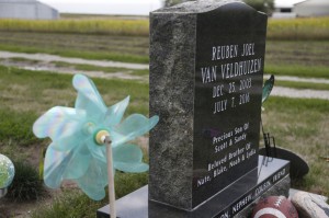 A football and a pinwheel are among the decorations on Reuben's grave at Evergreen Cemetery in Leighton, Iowa. (Michael Zamora/The Des Moines Register)