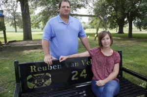 At their home in Oskaloosa, Iowa, Scott and Sandy Van Veldhuizen sit on a bench given to them by families of children who played sports with their son Reuben. (Michael Zamora/The Des Moines Register)