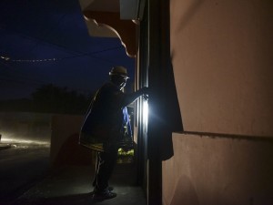 Puertorriqueña ingresa a su casa en la oscuridad de la noche que ha dejado a su paso el Huracán María. Foto: www.nationalpost.com.