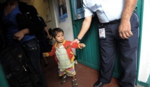 Un oficial de inmigración mexicano sostiene por el brazo a un niño centroamericano mientras su madre es deportada. Foto: AFP.