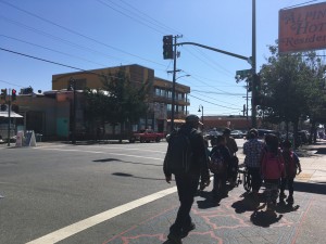 Familias caminan por el barrio de Fruitvale, donde se encuentra la Clínica de la Raza.