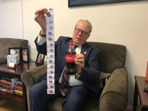 California Sen. Bill Monning (D-Carmel) displays the amount of sugar in a 20-ounce bottle of Coca-Cola. Monning is pushing legislation that would put health warning labels on sugary drinks. He describes the soda industry as a big influencer in California politics. (Samantha Young/Kaiser Health News)