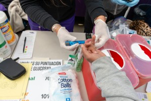 Las enfermeras voluntarias verifican los niveles de glucosa y la presión arterial de los pacientes.