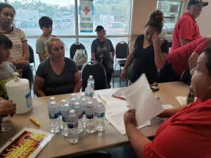  María Mesa, recibe instrucciones de Ronald Lira, voluntario de la Cruz Roja. Rubicely su vecina, la acompañan. 