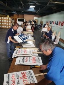 Trabajadores voluntarios laboran a todo vapor construyendo las pancartas.