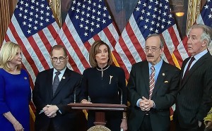 La presidente de la Cámara de Representantes, Nancy Pelosi flanqueada por un grupo de correligionarios demócratas haciendo uso de oa palabra para anunciar las acusaciones al presidente Trump.