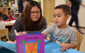 La maestra de educación preescolar, Rosa Bounkhoun escucha a un niño hablar sobre formas, en el Centro de Desarrollo Infantil Lighthouse for Children, en Fresno, California.