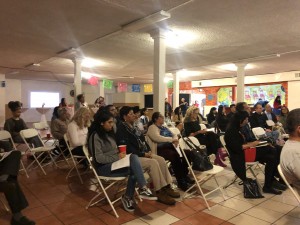 Comunidad, artistas y familiares del vecindario en el Este de Los Ángeles escuchando la presentación del libro SaludArte en el salón de La Casa Del Mexicano, celebraron los temas inspirados por los artistas. 