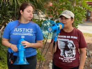 Nely rodríguez (derecha), organizadora de los trabajadores agrícolas de Immokalee, de camiseta guinda y con el megáfono transmitiendo un mensajes a los trabajadores mientras éstos laboran.