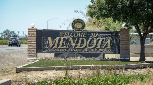 Un automóvil pasa por un cartel de bienvenida en la frontera sur de Mendota. Foto: Craig Kohlruss / The Fresno Bee.