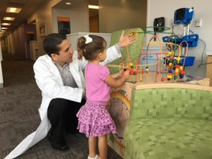 El Dr. Flores jugando con una de sus pacientes en el hospital. Foto: Mariana Pineda.