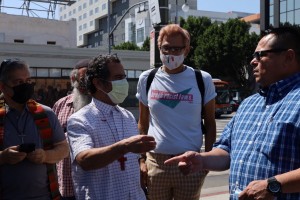 El activista Guillermo Torres -con crucifijo-, frente al banco Chase pide que se los políticos se desliguen de la empresa carcelera GEO Group. Foto: Cortesía.