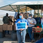 Montserrat Gómez, voluntaria de TODEC Legal Center, habla con trabajadores agrícolas sobre la vacuna contra covid-19. “Están asustados porque no tienen la información correcta”. Foto: Heidi de Marco.